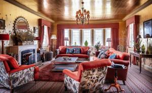 uma sala de estar com mobiliário vermelho e uma lareira em The Glenmorangie House em Tain