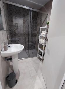 y baño con lavabo blanco y ducha. en La Casa Azul, en Santa Faç (Santa Faz)