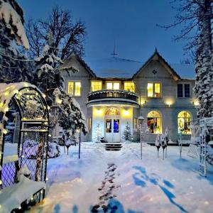 a house covered in snow with a gate at Art Residence in Jūrmala