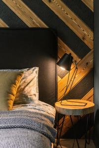 een slaapkamer met een bed en een lamp op een tafel bij Apartamenty Riders Lodge Szczyrk Olimpijska in Szczyrk