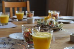 uma mesa com um copo de sumo de laranja e um prato de comida em Aux 4 Saules de 4 Wilgen em Modave