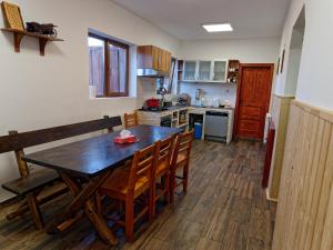 a kitchen with a wooden table and wooden chairs at Cabana Fundata in Fundata