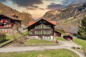 a large wooden house in a valley with mountains at Chalet Pironnet with BEST Views, Charm and Comfort! in Lauterbrunnen