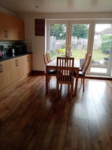 a dining room with a table and chairs and a kitchen at Comfy 3 bed house near Windsor Castle and Legoland in Windsor
