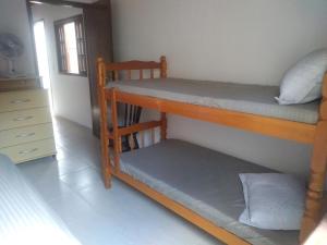 a room with two bunk beds and a dresser at Casa de praia Indaiá Bertioga in Bertioga