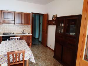 eine Küche mit einem Tisch, einer Spüle und einem Kühlschrank in der Unterkunft Villa Kalura A in Cefalú