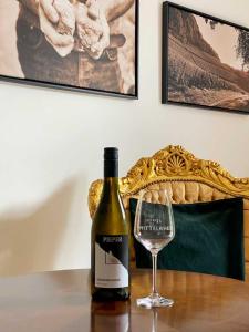 Weingut Pieper - Vinothek & Hotel am Drachenfels في باد هونيف آم راين: زجاجة من النبيذ وكأس على الطاولة