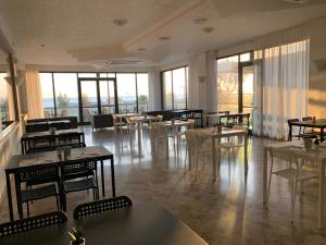 a restaurant with tables and chairs and windows at Hotel Tritone Rimini in Rimini