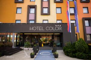 ein Hotelgebäude mit aigil farbenem Schild davor in der Unterkunft Hotel Color in Bratislava