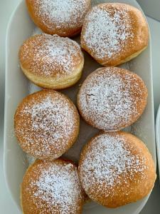 a plate of donuts covered in powdered sugar at Hotel Tritone Rimini in Rimini