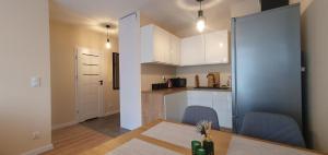 a kitchen and dining room with a table and chairs at APARTAMENT KAZART.PL 5 CENTURM/PLAC UNII in Gdynia