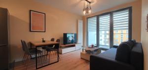 a living room with a couch and a table and a television at APARTAMENT KAZART.PL 5 CENTURM/PLAC UNII in Gdynia