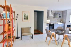 - une cuisine et une salle à manger avec une table et des chaises dans l'établissement L’appartement - Jardin Secret, à Marseille