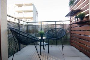 eine Terrasse mit 2 Stühlen und einem Tisch auf dem Balkon in der Unterkunft Apartament Loftowy Wypoczynek GoldAir in Posen