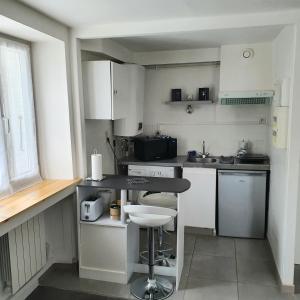 a kitchen with white cabinets and a black counter top at *** STUDIO 39 *** in Morbier