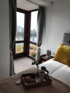 a bedroom with a bed with a window and a tray of food at Tiger House Luxury Riverside Home in Stockton-on-Tees