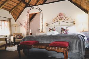 una camera da letto con un grande letto e un grande specchio di Cottage Pie a Clarens