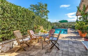 un patio con tavolo e sedie accanto alla piscina di Beautiful Home In Alvignano With Kitchen ad Alvignano