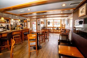 um restaurante com mesas e cadeiras de madeira e um bar em The Raven Suite at Stoneridge Mountain Resort em Canmore