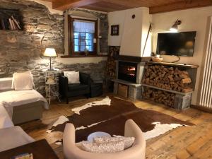 a living room with a fireplace and a stone wall at Maison Bovet Mont Blanc in La Salle