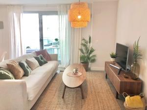 ein Wohnzimmer mit einem weißen Sofa und einem Tisch in der Unterkunft Brand new 2 bedroom apartment in Duna Beach, Torrox Costa in Torrox Costa