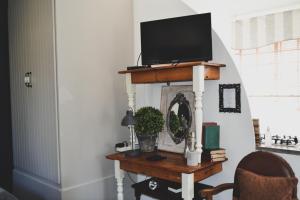 un soggiorno con tavolo e TV sopra di Cottage Pie a Clarens