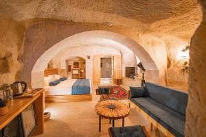 a room with a bed and a couch in a cave at Agarta Cave Hotel in Goreme