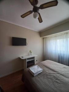 a bedroom with a ceiling fan and a bed at Hotel América in Mar del Plata