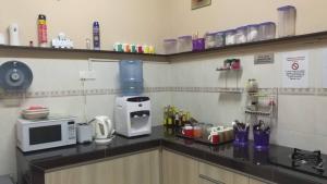 uma cozinha com um micro-ondas e comodidades para preparar café num balcão em Cosy P6 Homestay em Puchong