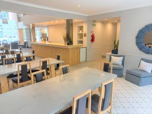 a restaurant with tables and chairs in a room at Hotel América in Mar del Plata