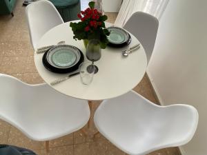 a white table with a vase of flowers on it at Boho-Chic one bedroom flat in Engomi in Engomi