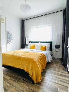 a bedroom with a large bed with a yellow blanket at Boho-Chic one bedroom flat in Engomi in Engomi