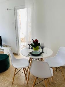 a white dining room table with four white chairs at Boho-Chic one bedroom flat in Engomi in İncirli