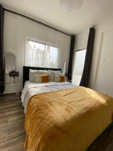 a large bed in a bedroom with a large window at Boho-Chic one bedroom flat in Engomi in İncirli
