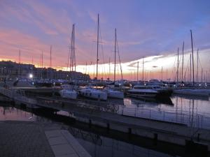 a group of boats docked in a marina at sunset at Hotel San Rocco in Muggia