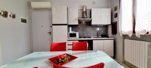 a small kitchen with a table and red chairs at GUEST HOLIDAY BARI in Reggio Emilia +14 photos