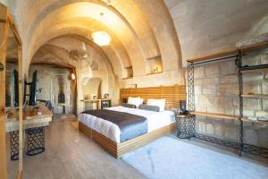 um quarto com uma cama grande num quarto com tectos em Agarta Cave Hotel em Goreme