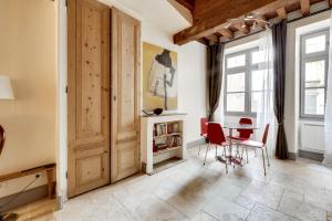 a room with a table and chairs and windows at La Maison Debourg in Lyon