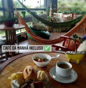 uma mesa com um prato de comida e uma chávena de café em Joaquina 433 - Pousada Floripa em Florianópolis