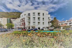 a large white building in front of a street at White Waters Hotel in Machico
