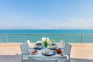 einen Tisch mit Teller mit Speisen auf dem Balkon in der Unterkunft Residenza Miralago by Wonderful Italy in Desenzano del Garda