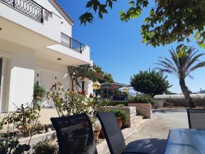 una mesa y sillas frente a una casa en Swan House Panoramic View - Near the sea, en Zipárion