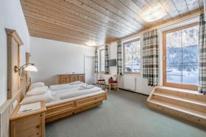 1 Schlafzimmer mit 2 Betten und einem großen Fenster in der Unterkunft Hotel Fischer am See in Heiterwang