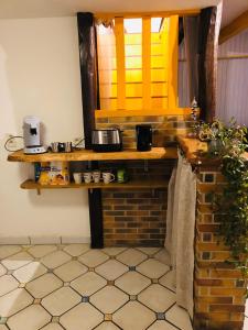 a kitchen with a counter and a shelf in a room at P’tite House in Bretenoux