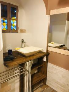 La salle de bains est pourvue d'un lavabo et d'un miroir. dans l'établissement P’tite House, à Bretenoux