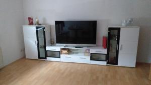 a living room with a tv and a white entertainment center at Ferienwohnung Fam.Lutz in Knittelsheim