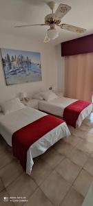 sypialnia z dwoma łóżkami i obrazem na ścianie w obiekcie Castle HARBOUR 425 w mieście Los Cristianos