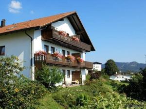 una casa con un balcón con flores. en FW Zum Königshang en Bodenmais