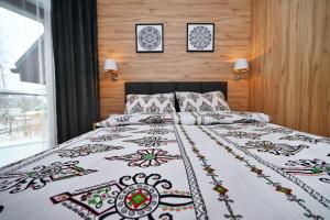 sypialnia z łóżkiem z ozdobną narzutą w obiekcie Malinova 36 w Wiśle