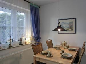 ein Esszimmer mit einem Holztisch und einem Fenster in der Unterkunft Ferienwohnung O1 in Graal-Müritz